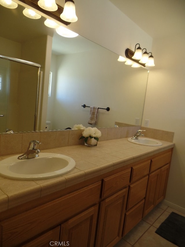 bathroom featuring vanity, a shower with shower door, toilet, and tile patterned floors