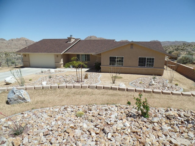 view of front of home with a garage and a mountain view