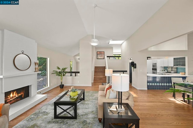 living room featuring light wood-type flooring and vaulted ceiling