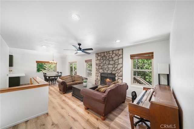 living room featuring ceiling fan, a fireplace, a healthy amount of sunlight, and light hardwood / wood-style flooring