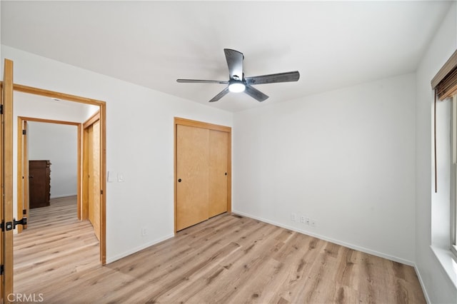 unfurnished bedroom with light hardwood / wood-style flooring, a closet, and ceiling fan