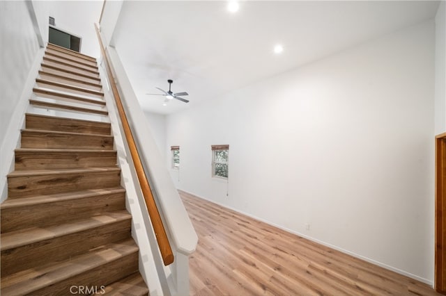 stairway featuring ceiling fan and hardwood / wood-style flooring