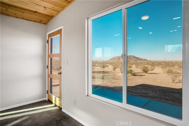 doorway to outside with wooden ceiling, a healthy amount of sunlight, dark carpet, and a mountain view