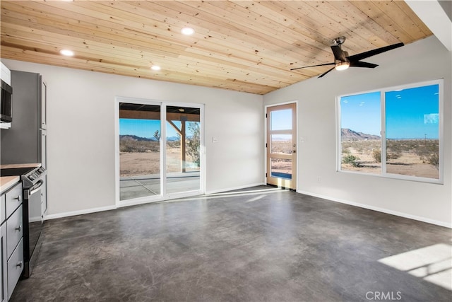 unfurnished living room featuring wood ceiling, a mountain view, ceiling fan, and plenty of natural light