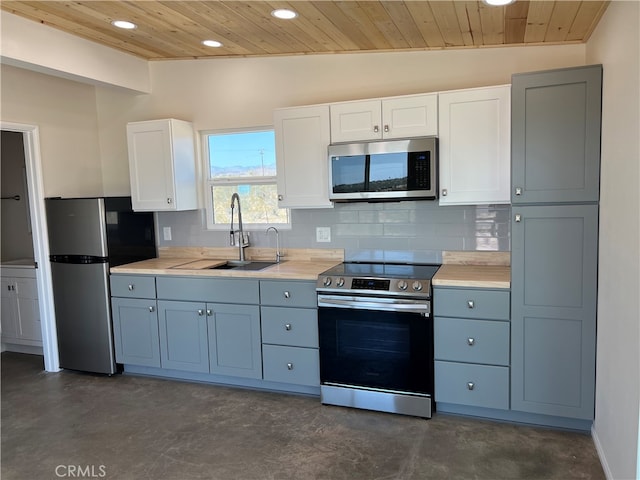 kitchen with decorative backsplash, vaulted ceiling, white cabinets, stainless steel appliances, and wooden ceiling