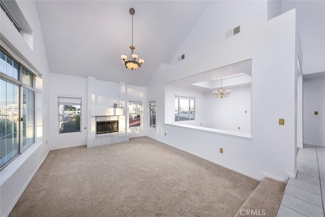 unfurnished living room with a healthy amount of sunlight, a fireplace, and a chandelier