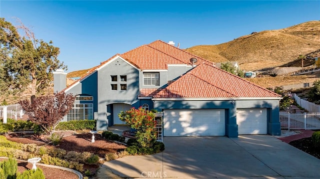 mediterranean / spanish-style home with a garage and a mountain view