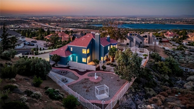 aerial view at dusk featuring a water view