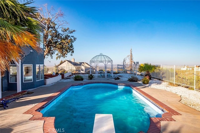 view of swimming pool with a diving board