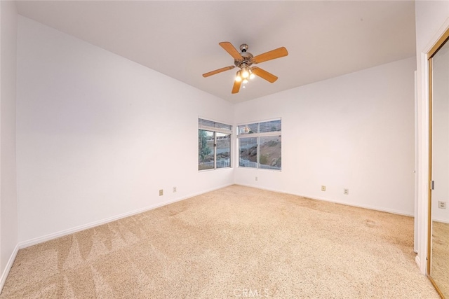 carpeted spare room with ceiling fan