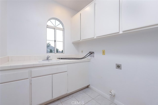 laundry room with light tile patterned flooring, sink, cabinets, hookup for a washing machine, and electric dryer hookup