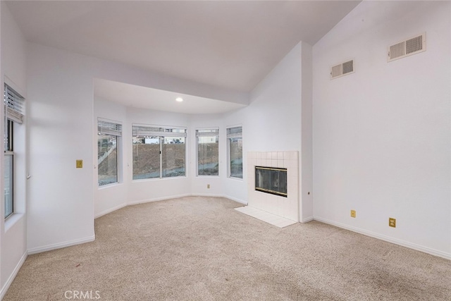 unfurnished living room with light carpet, a fireplace, and vaulted ceiling