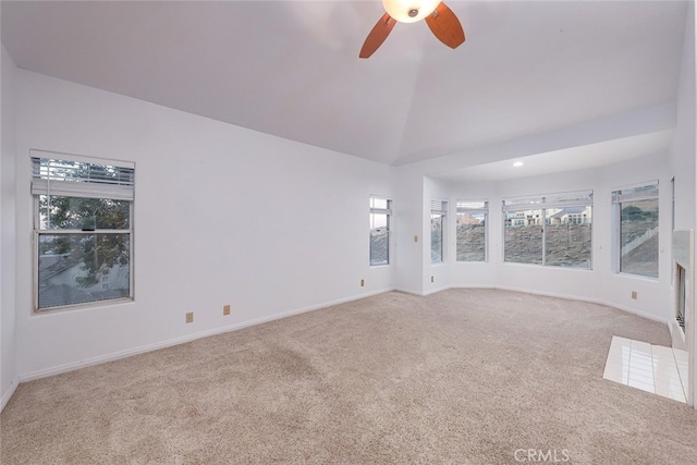 unfurnished living room with lofted ceiling, a wealth of natural light, light carpet, and ceiling fan