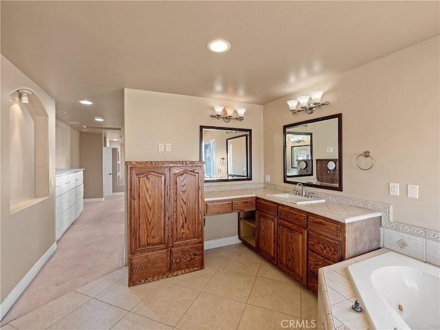 bathroom featuring an inviting chandelier, tile patterned flooring, tiled tub, and vanity