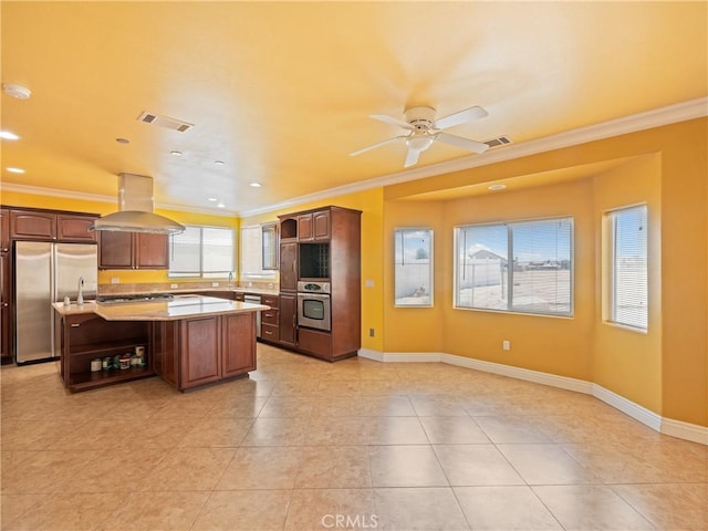 kitchen featuring built in fridge, dark brown cabinetry, a center island, and island range hood