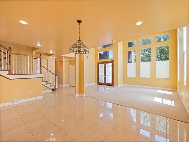 carpeted spare room featuring crown molding and french doors