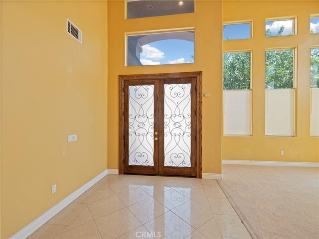 entrance foyer featuring light carpet and french doors