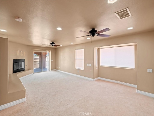 unfurnished living room with ceiling fan and light colored carpet