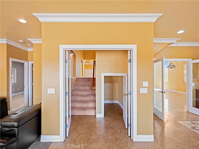 corridor with french doors, light tile patterned flooring, and ornamental molding