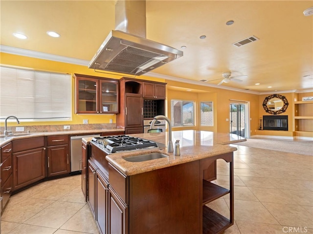 kitchen with island range hood, an island with sink, appliances with stainless steel finishes, a kitchen breakfast bar, and sink