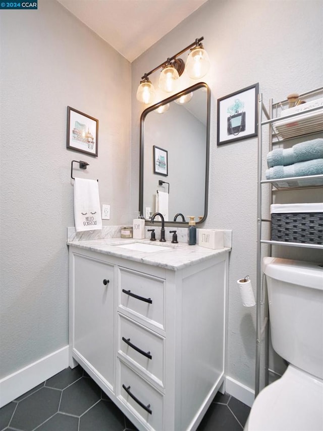 bathroom featuring toilet, tile patterned flooring, and vanity