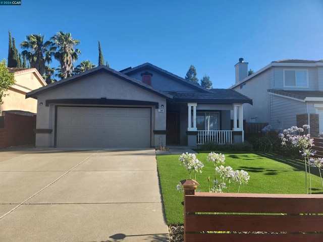 view of front of home with a porch, a front lawn, and a garage