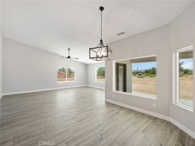 interior space featuring ceiling fan with notable chandelier and light hardwood / wood-style flooring