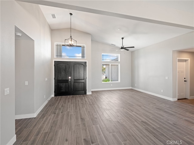 entryway featuring ceiling fan with notable chandelier, vaulted ceiling, and dark hardwood / wood-style floors