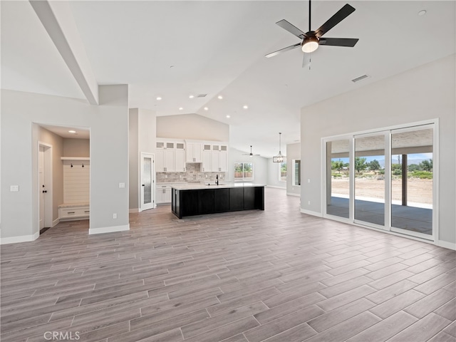 unfurnished living room featuring light wood-type flooring, lofted ceiling, and ceiling fan