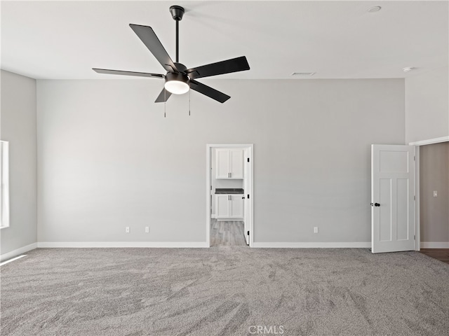 carpeted spare room featuring ceiling fan