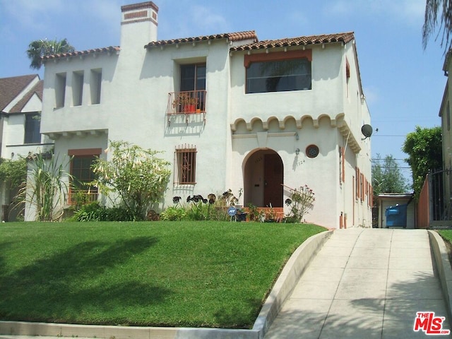 mediterranean / spanish home featuring a front lawn