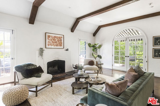 living room with hardwood / wood-style floors, lofted ceiling with beams, and french doors