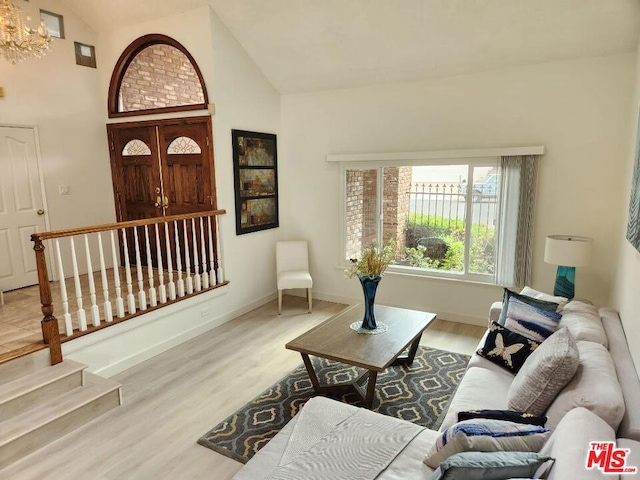 living room with hardwood / wood-style floors and high vaulted ceiling