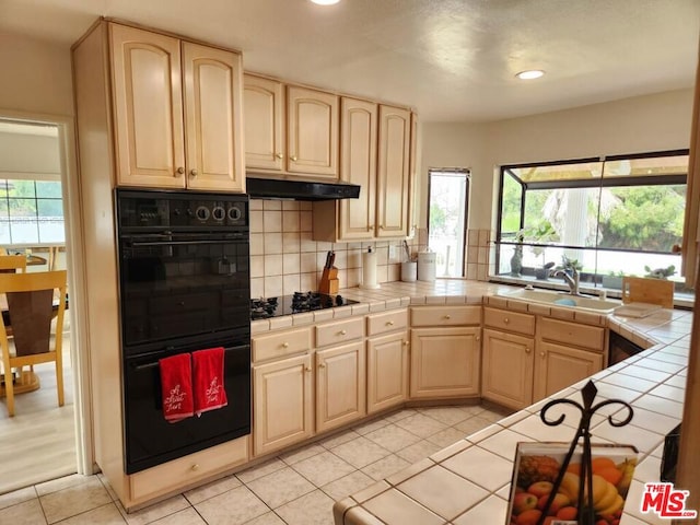 kitchen featuring tile countertops, black appliances, sink, and light brown cabinets