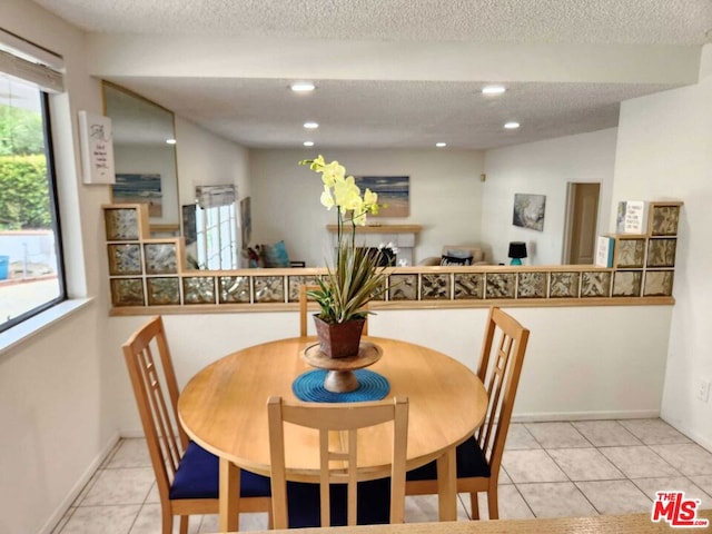 dining area featuring a textured ceiling and light tile patterned floors