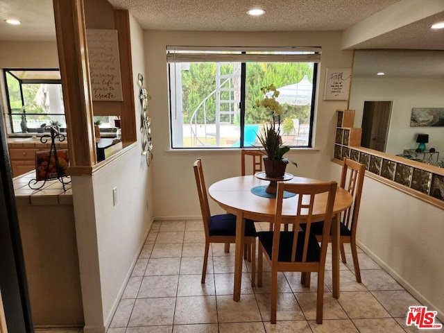 dining room with a textured ceiling and light tile patterned flooring