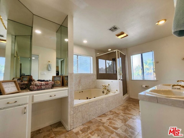 bathroom featuring vanity and independent shower and bath