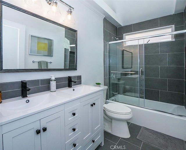 full bathroom featuring toilet, bath / shower combo with glass door, tile patterned flooring, and vanity