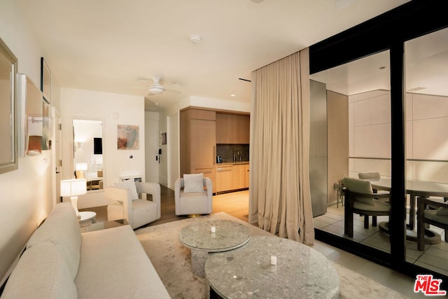 living room with sink, ceiling fan, and light tile patterned floors