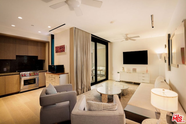 living room featuring light hardwood / wood-style floors and ceiling fan