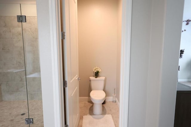 bathroom featuring tile patterned floors, toilet, and a shower with shower door