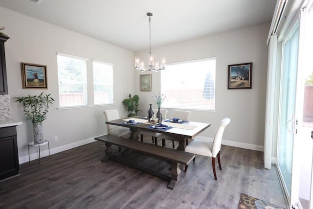 dining space with wood-type flooring and an inviting chandelier