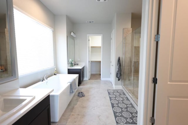 bathroom featuring tile patterned floors, vanity, and shower with separate bathtub