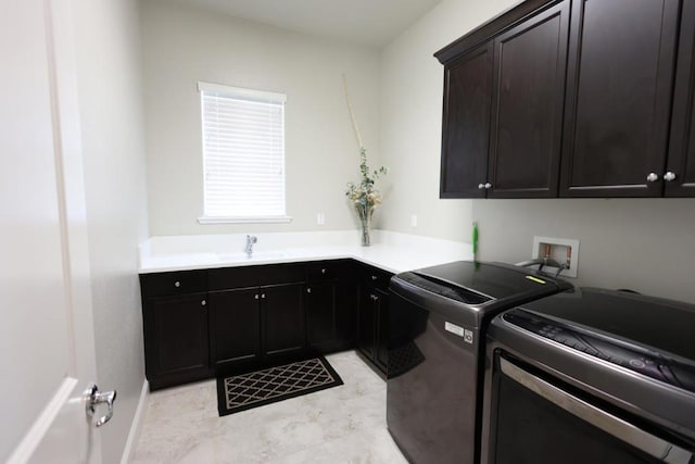 laundry room with washing machine and clothes dryer, sink, and cabinets