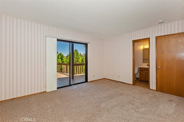 carpeted spare room featuring a textured ceiling