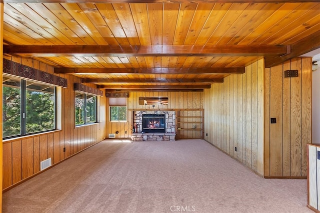 unfurnished living room with light carpet, wood ceiling, wood walls, and a fireplace