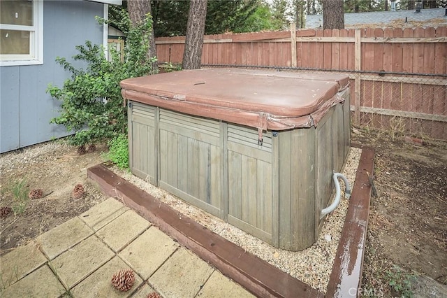 exterior space with fence and a hot tub