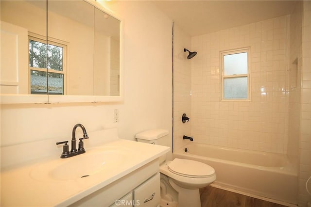 full bathroom with toilet, hardwood / wood-style floors, vanity, and tiled shower / bath