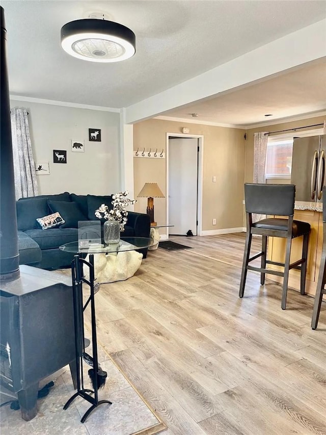 living room with ornamental molding, baseboards, and wood finished floors