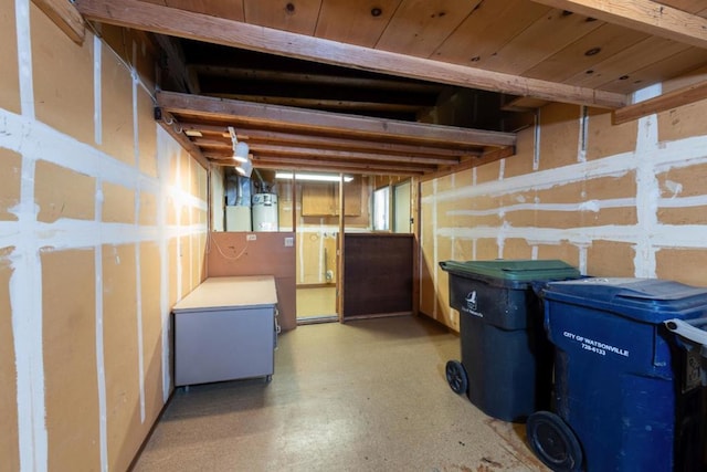 basement featuring water heater, fridge, and wooden ceiling